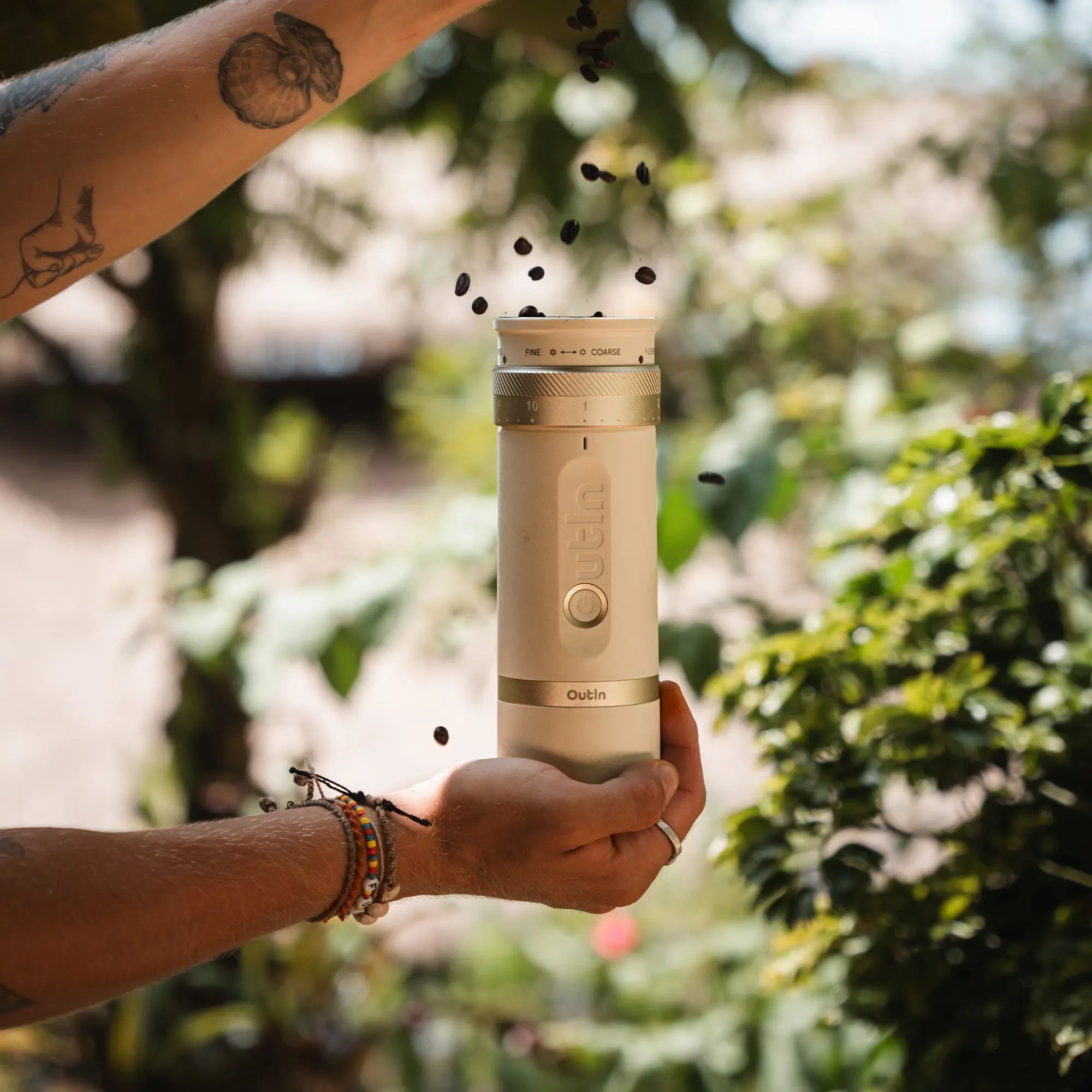 Person pouring coffee beans into Outin Fino portable grinder