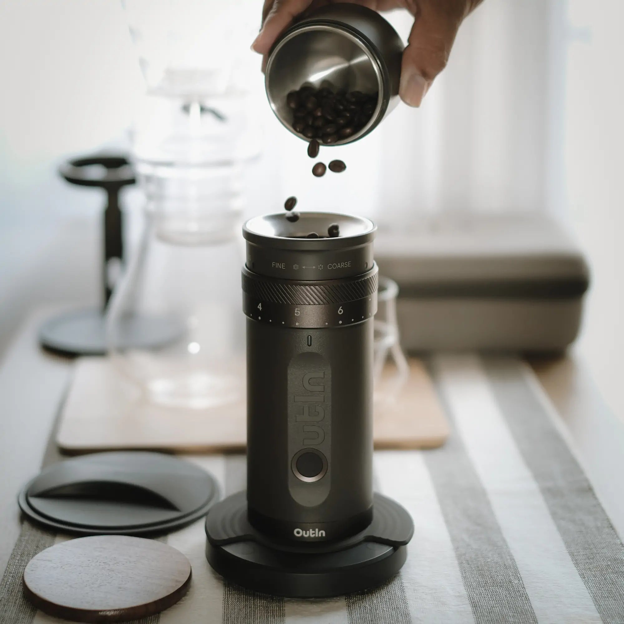 Outin Fino portable electric coffee grinder, pouring coffee beans