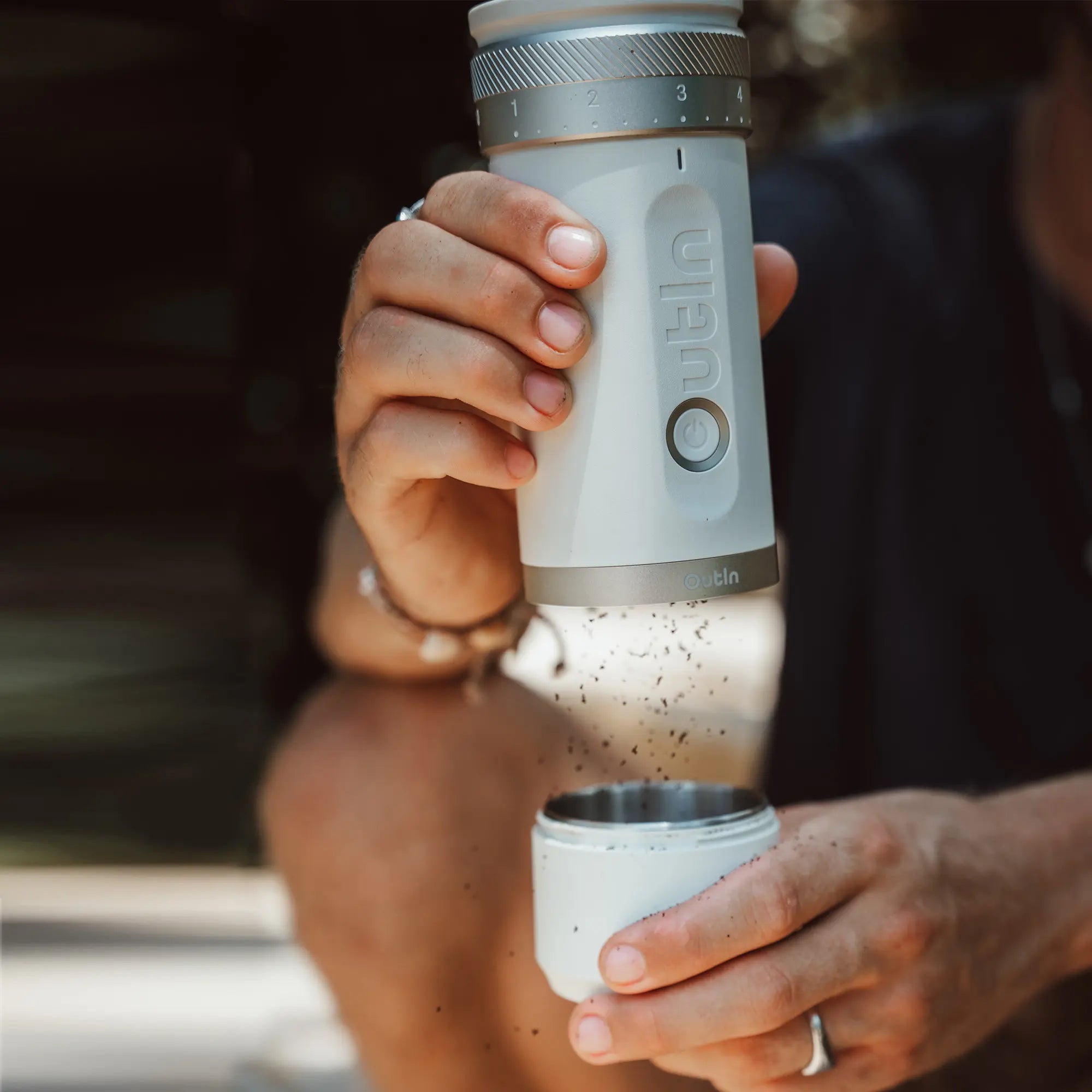 Outin Fino Portable Coffee Grinder grinding coffee beans.