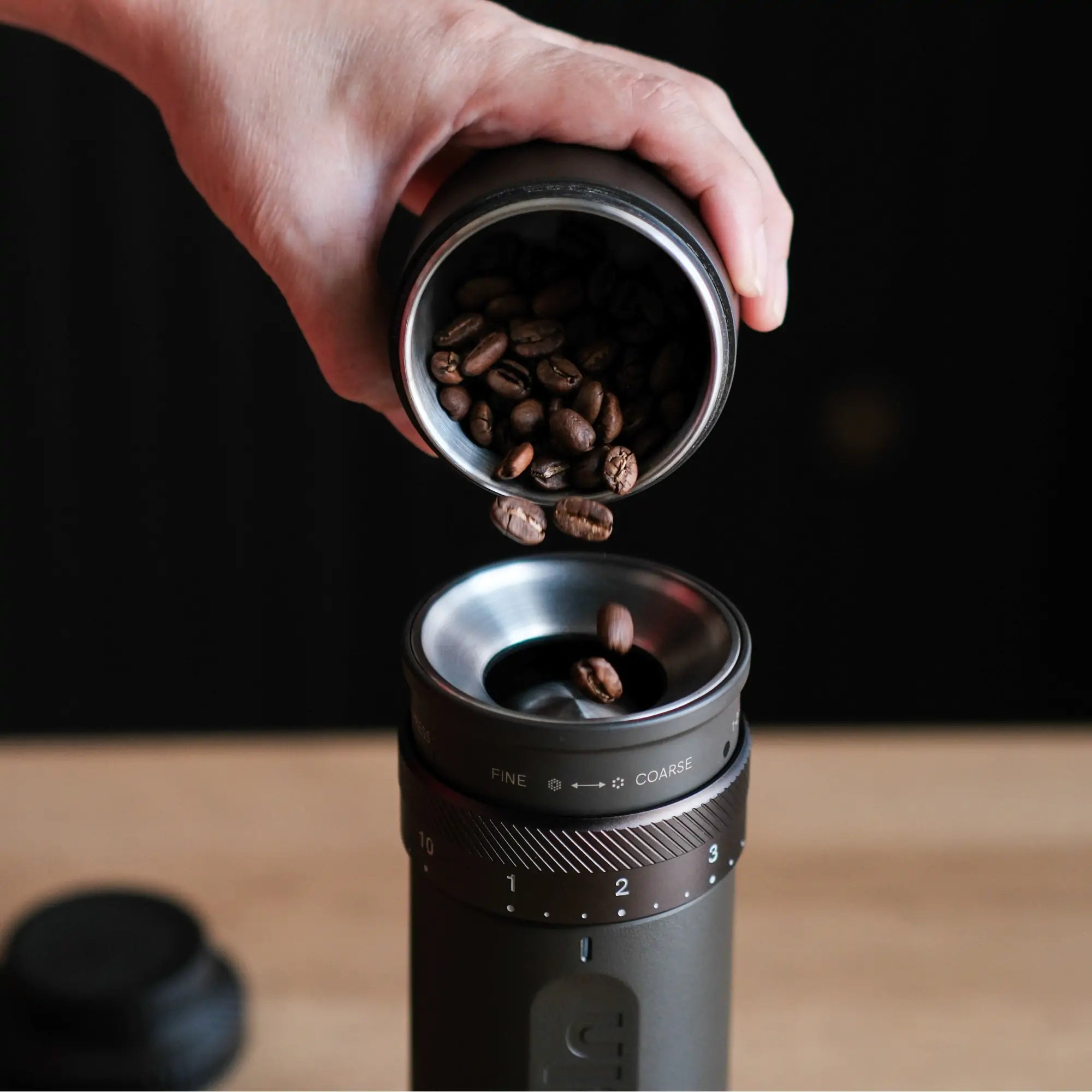 Pouring coffee beans into Outin Fino portable grinder